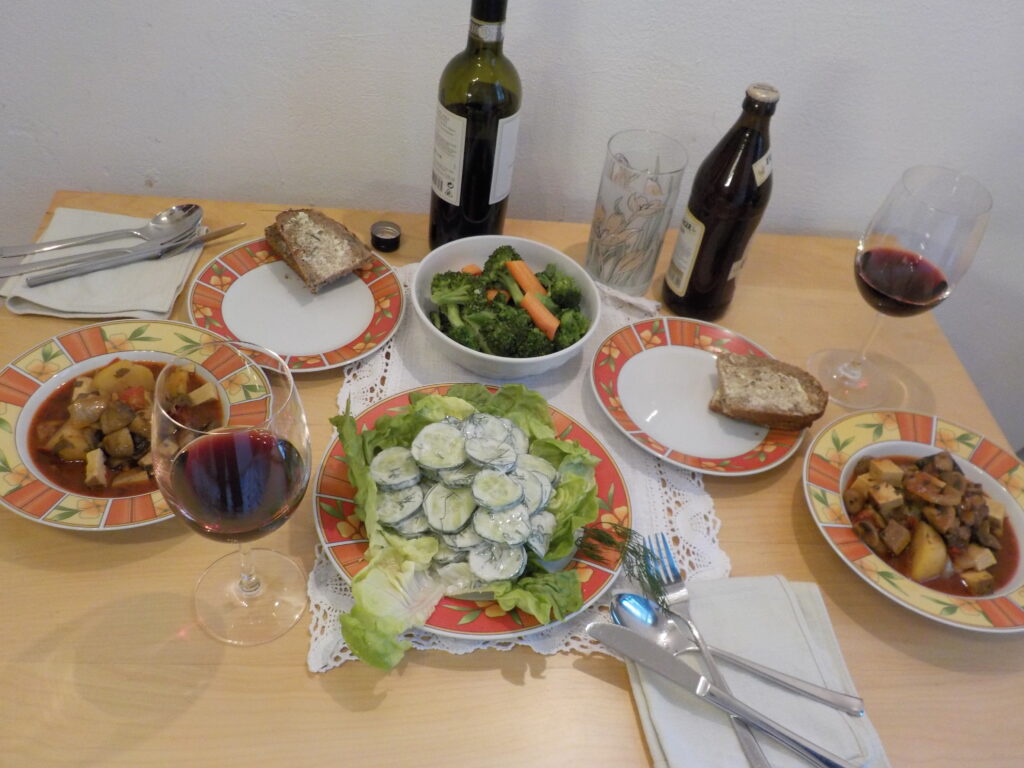 Table spread of salad, bread, and a main dish of meat and potatoes