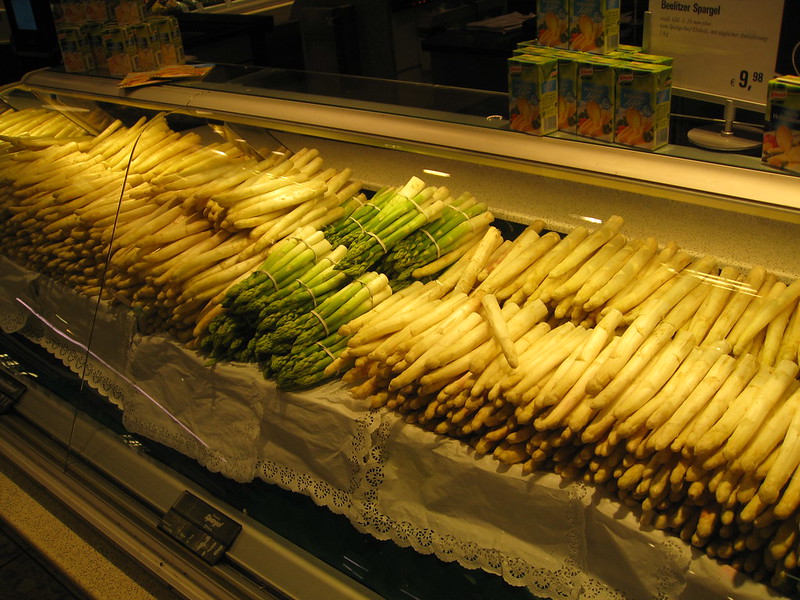 Decorative photo of white & green asparagus on display in a market.
