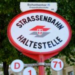 Red and white sign that reads Strassenbahn and Haltestelle