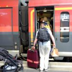 Man entering a train with backpack and luggage